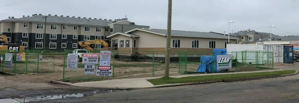 a house that has a sign on the side of a road