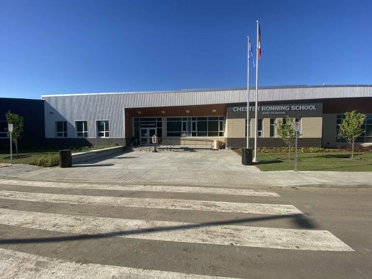 a building that has a sign on a dirt road