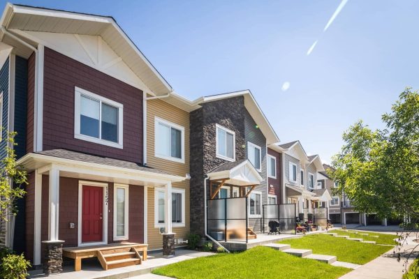 a large brick building with grass in front of a house