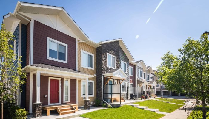 a large brick building with grass in front of a house