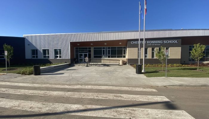 a building that has a sign on a dirt road