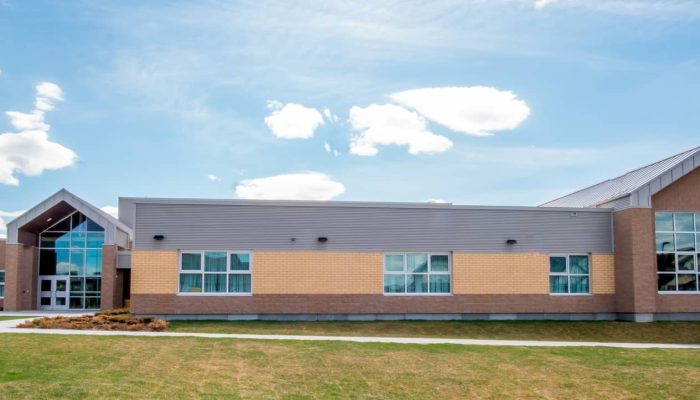 a large brick building with grass in front of a house